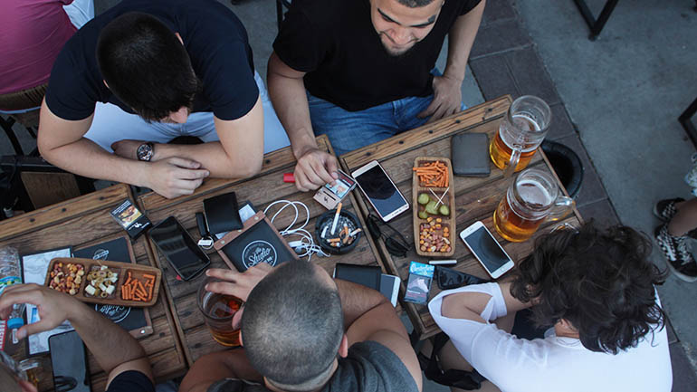 Marketing to millennials - people around a table with phones out
