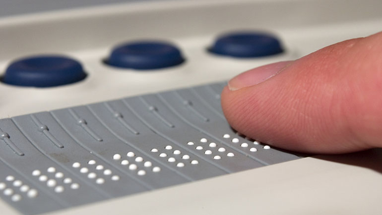 A person using a braille device for blind computer users